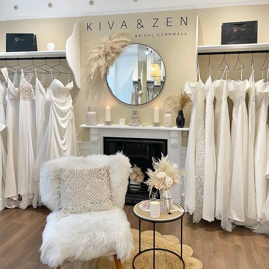 Stylish bridal shop interior with white dresses, a fireplace, and decorative elements.