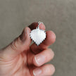 handmade silver birch leaf necklace held between fingers