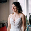 Bride wearing silver and pearl wedding jewellery with her lace wedding dress indoors
