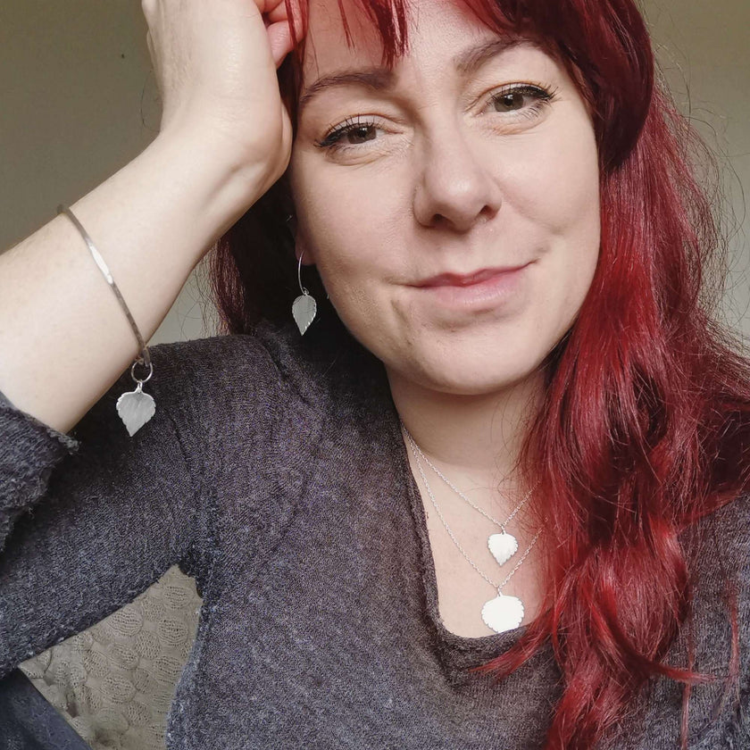 Cat Birch, a red haired young woman, wearing the silver birch leaf collection - handmade necklaces and earrings and bangle featuring silver birch leaves