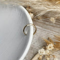 lightweight handmade hammered Gold ear cuff on a textured surface with dried flowers 