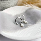 Silver studs with pearl details on a fabric background
