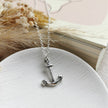 handmade silver anchor with silver chain on a white ceramic dish