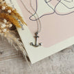 handmade silver anchor with silver chain on a pale pink and cream book cover by Rupi Kaur
