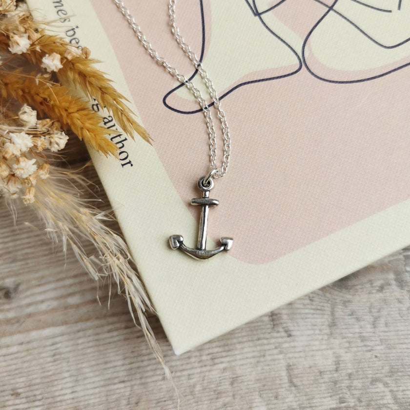handmade silver anchor with silver chain on a pale pink and cream book cover by Rupi Kaur