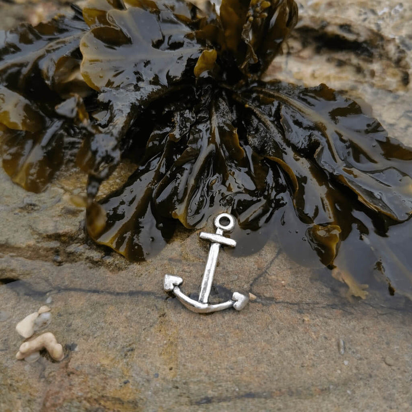 Silver anchor pendant in a cornish rockpool with seaweed