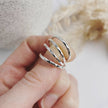 Hand holding hammered silver rings with a blurred background