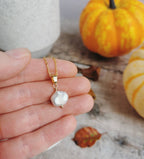 Two dainty Keishi pearl necklaces with one in silver and the other in gold-filled, displayed on a person's hand.