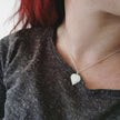 Young woman wearing a silver necklace with a birch leaf-shaped pendant